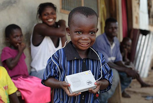 A child holds a SonSet radio in Ghana.