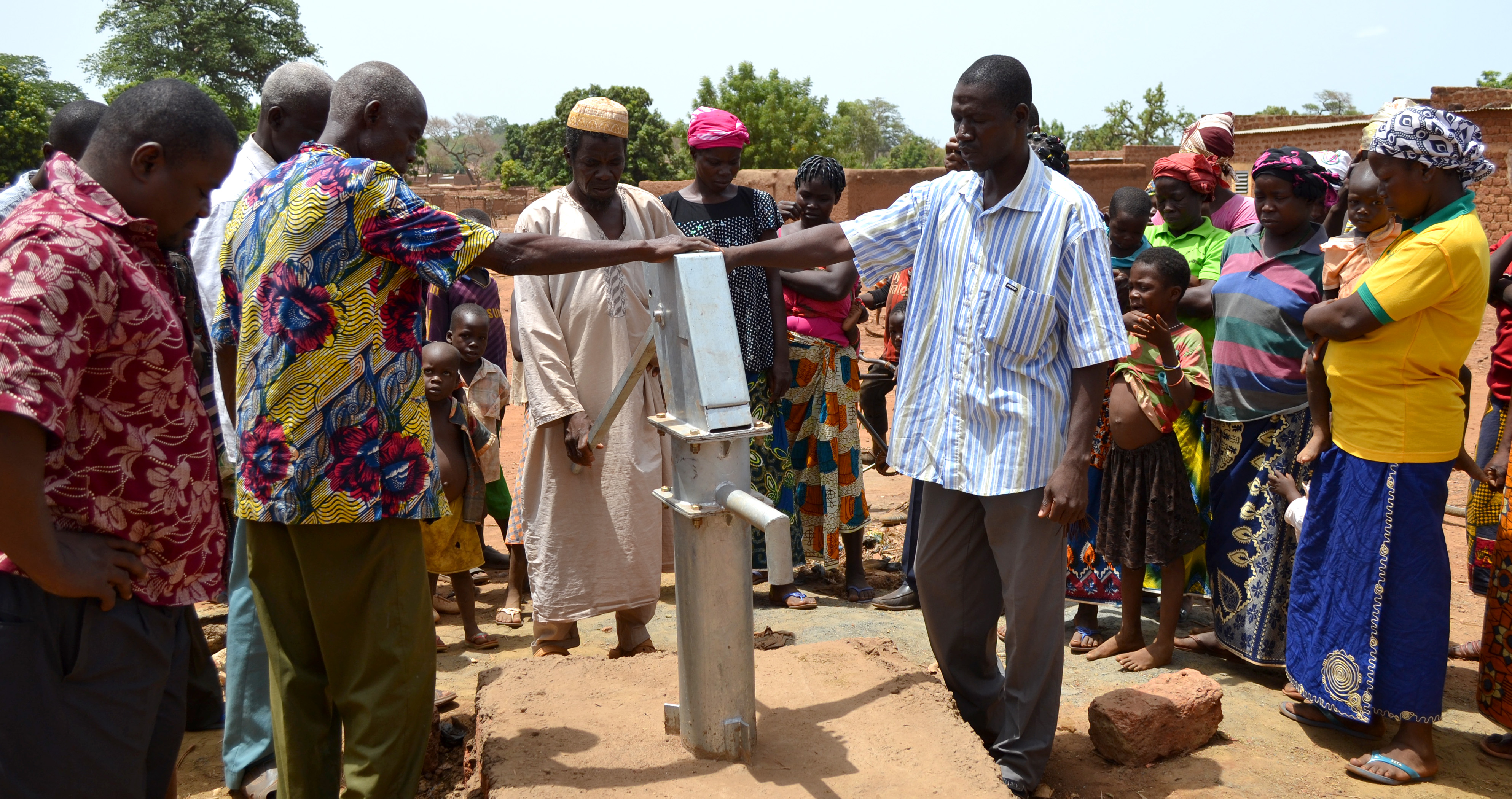Local residents pray over the new well during the dedication ceremony on June 9.