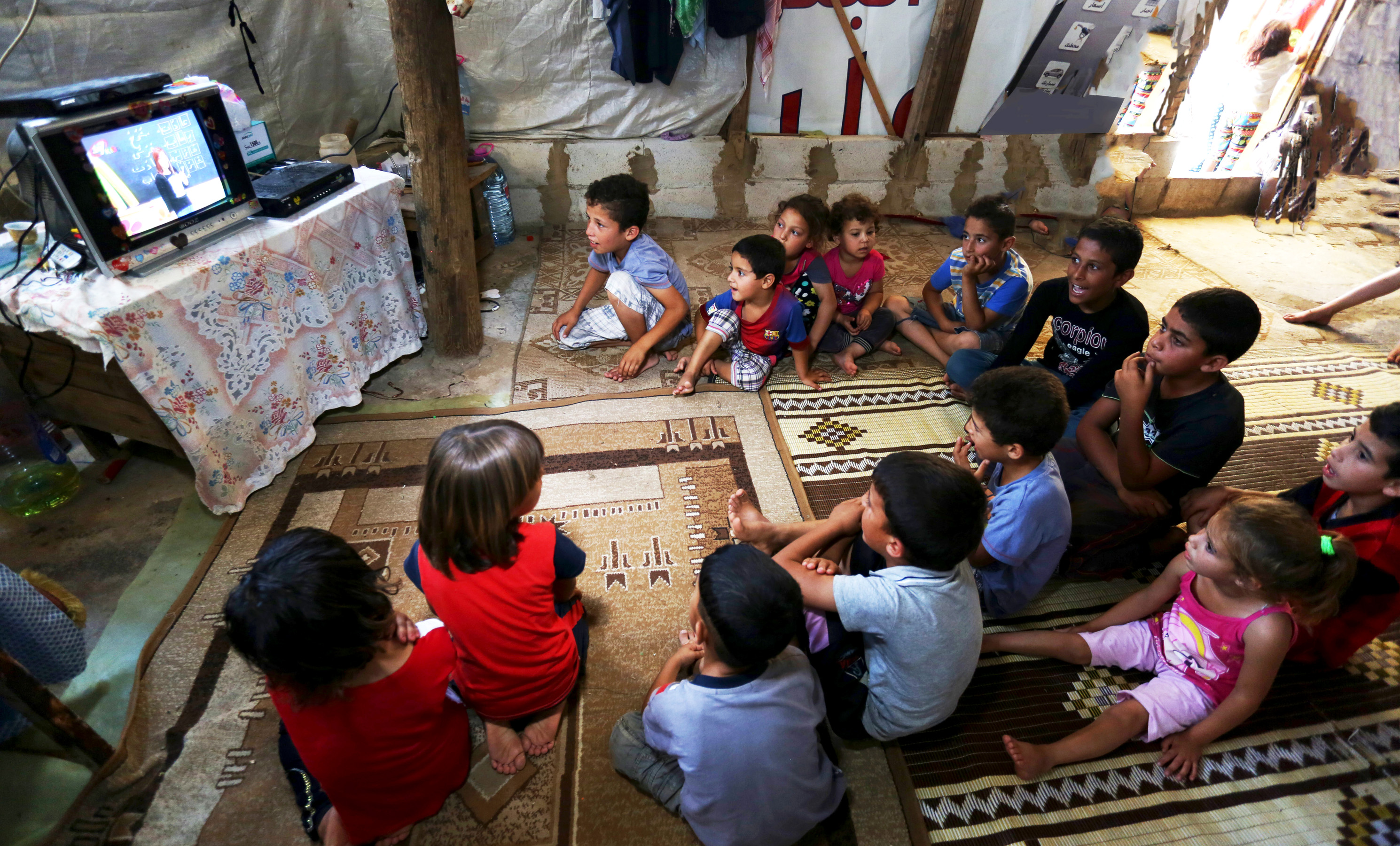 Young Syrian refugees in Lebanon watch a program from SAT-7.