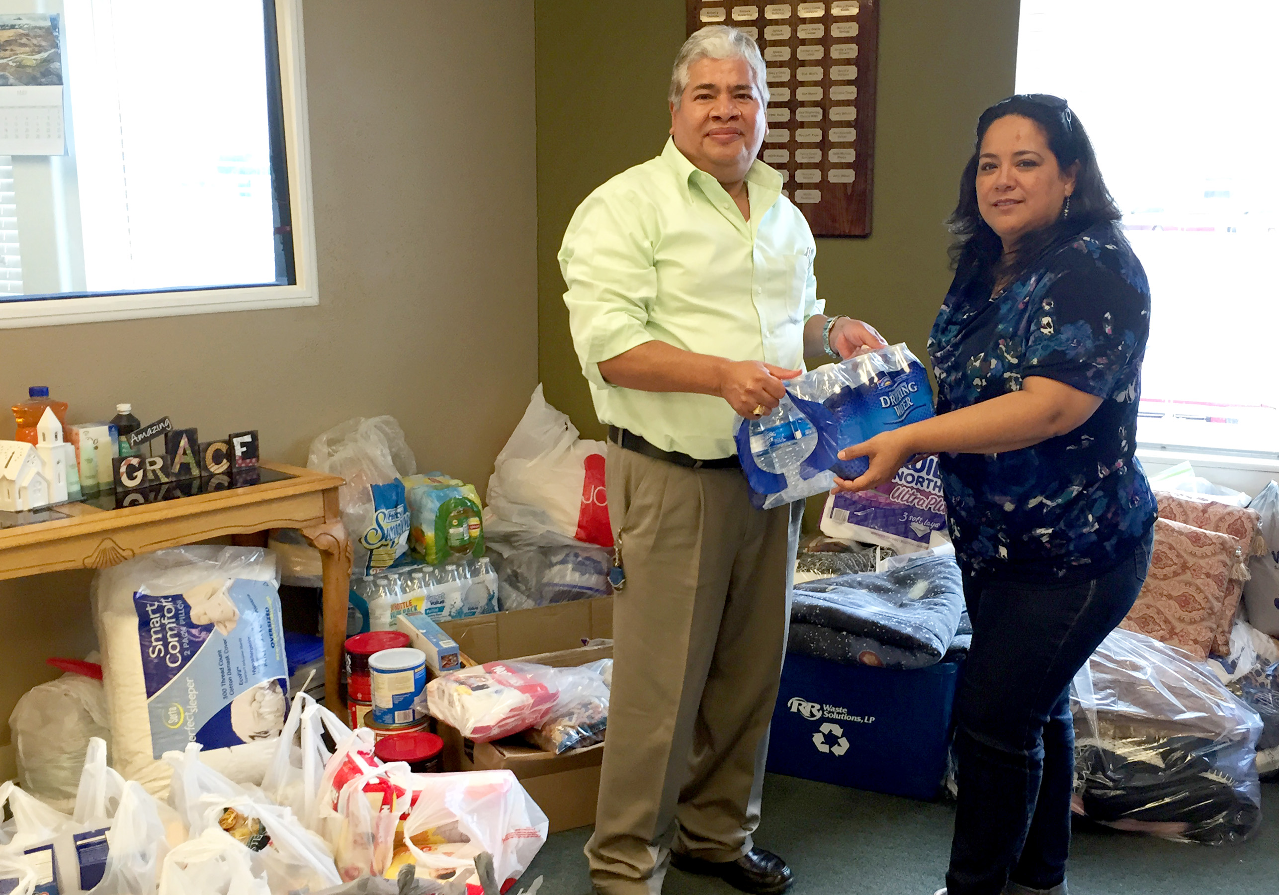 Rosie Rabell, manager of KVFE-FM in Del Rio, Texas, receives a donation of bottled water from a listener. Contributed items are being delivered to tornado victims in nearby Acuña, Mexico.