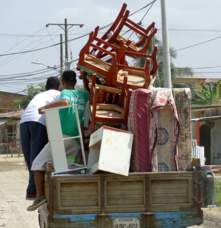 A displaced family moves their belongings to a new location.