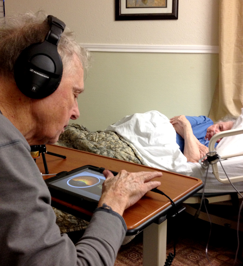 Dick Farstad prepares to upload a radio program to the Internet while Jane looks on.