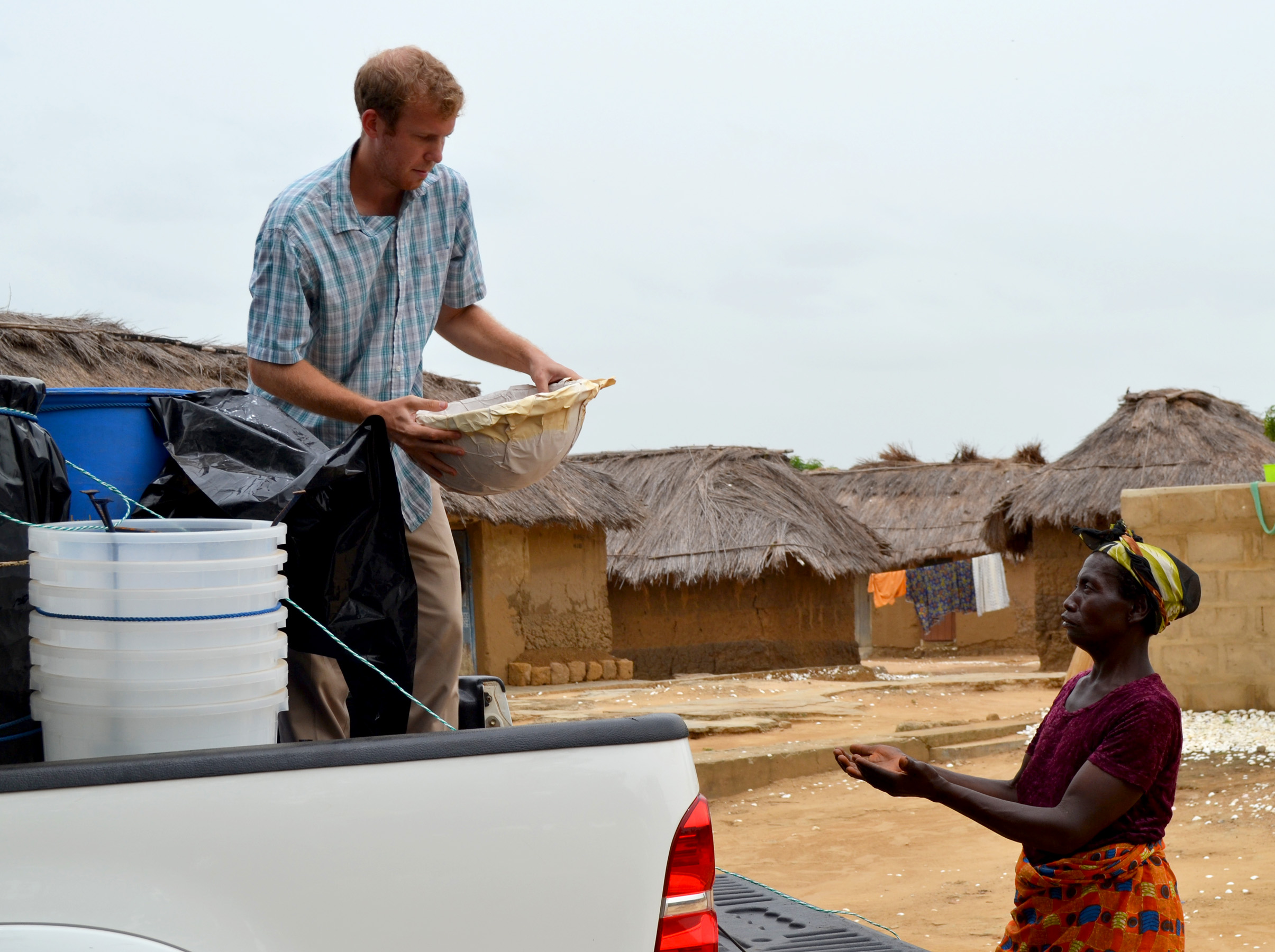 Andrew Rescorla hands a local villager a clay water filter.