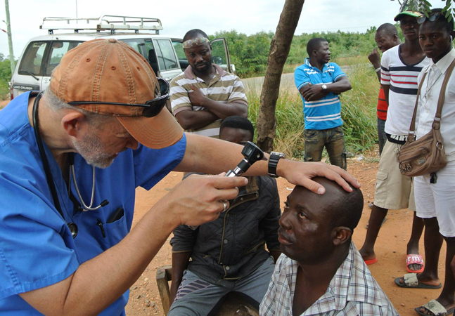 Dr. Joe Martin examines a patient's eyes in a remote community of Ghana.