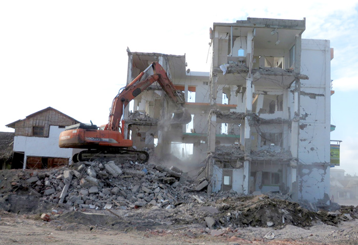 Heavy equipment is brought in to demolish buildings such as this one in hard-hit Canoa that were deemed irreparable as a result of the April 16 quake.