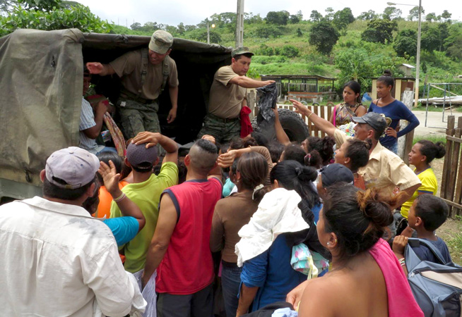 Ecuadorian soldiers distribute basic supplies to quake victims.