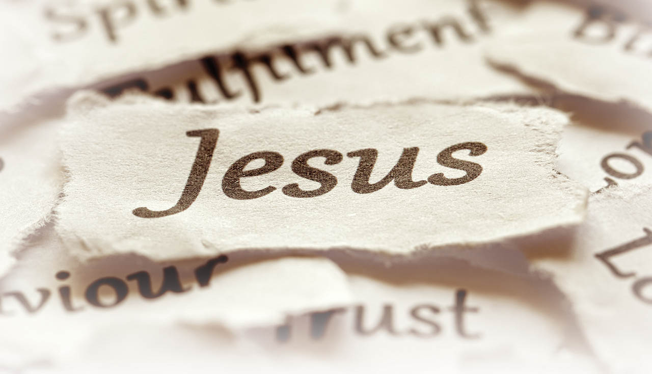 Illustration showing pieces of papers with different words with the focus point on a piece that says Jesus.