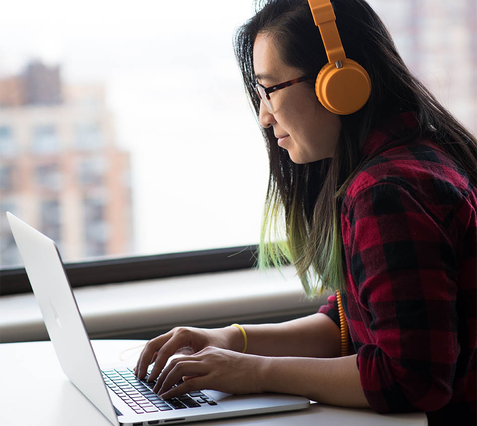 Asian woman on laptop with headphones