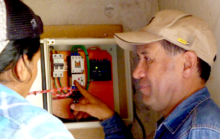 Cesar Cortez (right) with Edison Caiza at the control panel of a clean water system in Yalare, Ecuador.