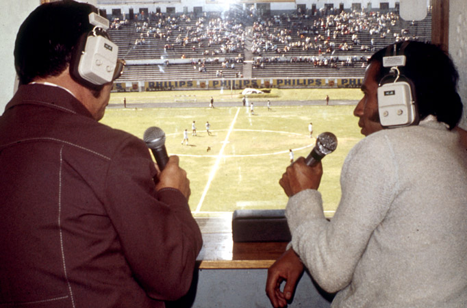 News and sports were a key part of HCJB-AM’s coverage, along with music and the arts. Above: Lenin de Janon (left) provides play-by-play during a soccer match.