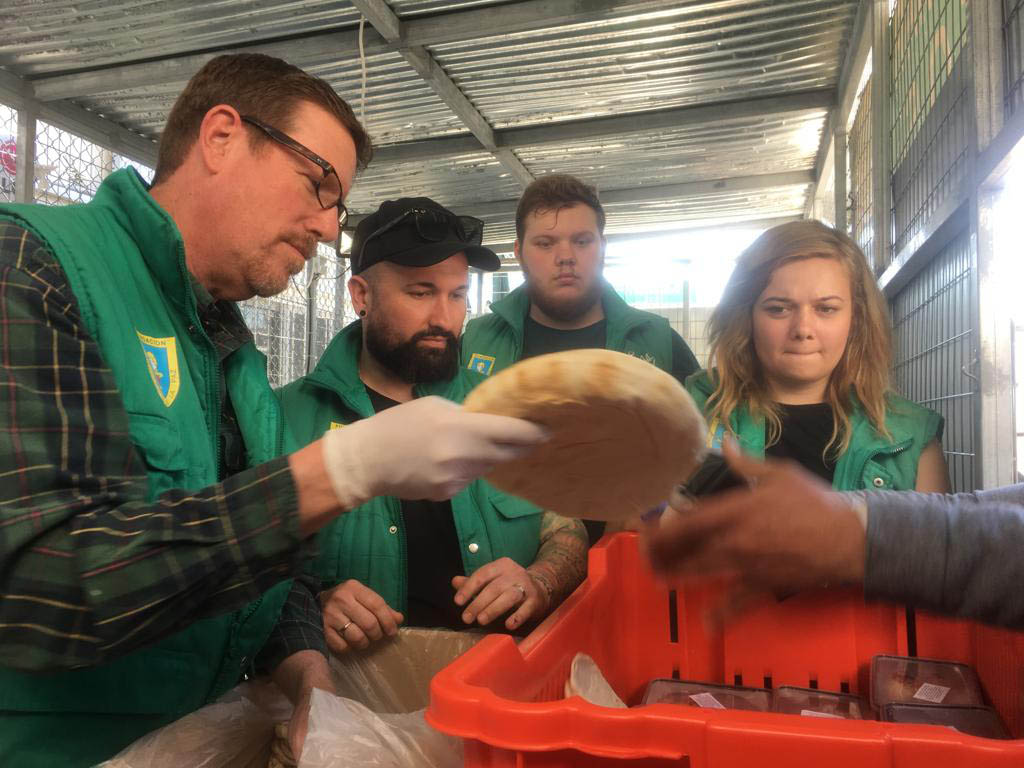 Team members help hand out food at the Moria refugee camp