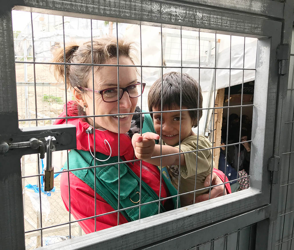 Holding a smiling child at the Moria Refugee Camp in Greece