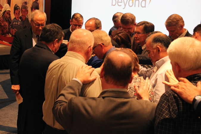 Colleagues gather around Steve Harling to for a time of prayer to conclude the inauguration.