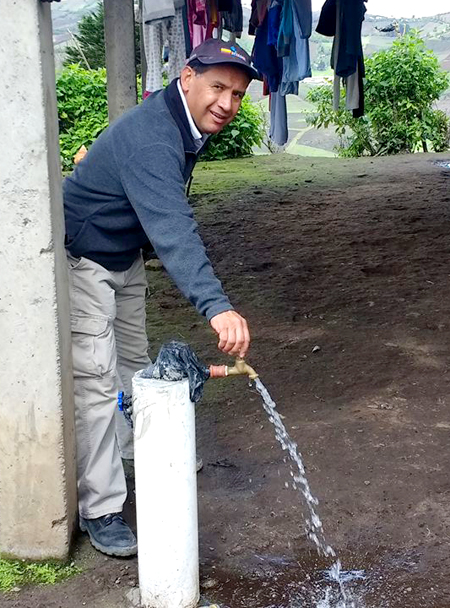 Reach Beyond's César Cortez tests one of the newly installed faucets installed at 53 homes in the community.