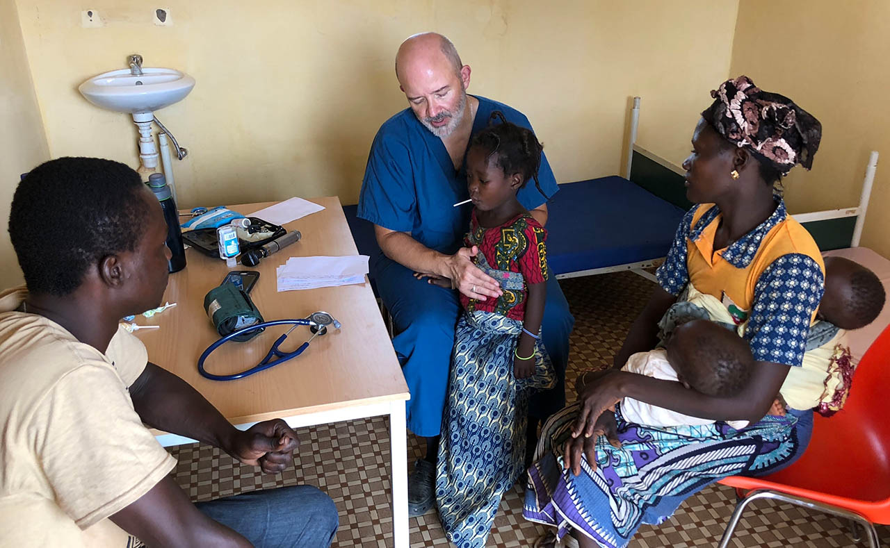 Dr Joe examines a child during a medical outreach in Burkina Faso