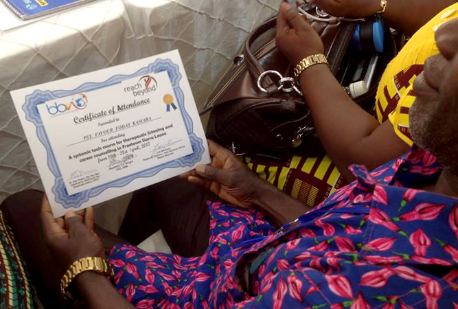 A BBN pastor admires his certificate of attendance.