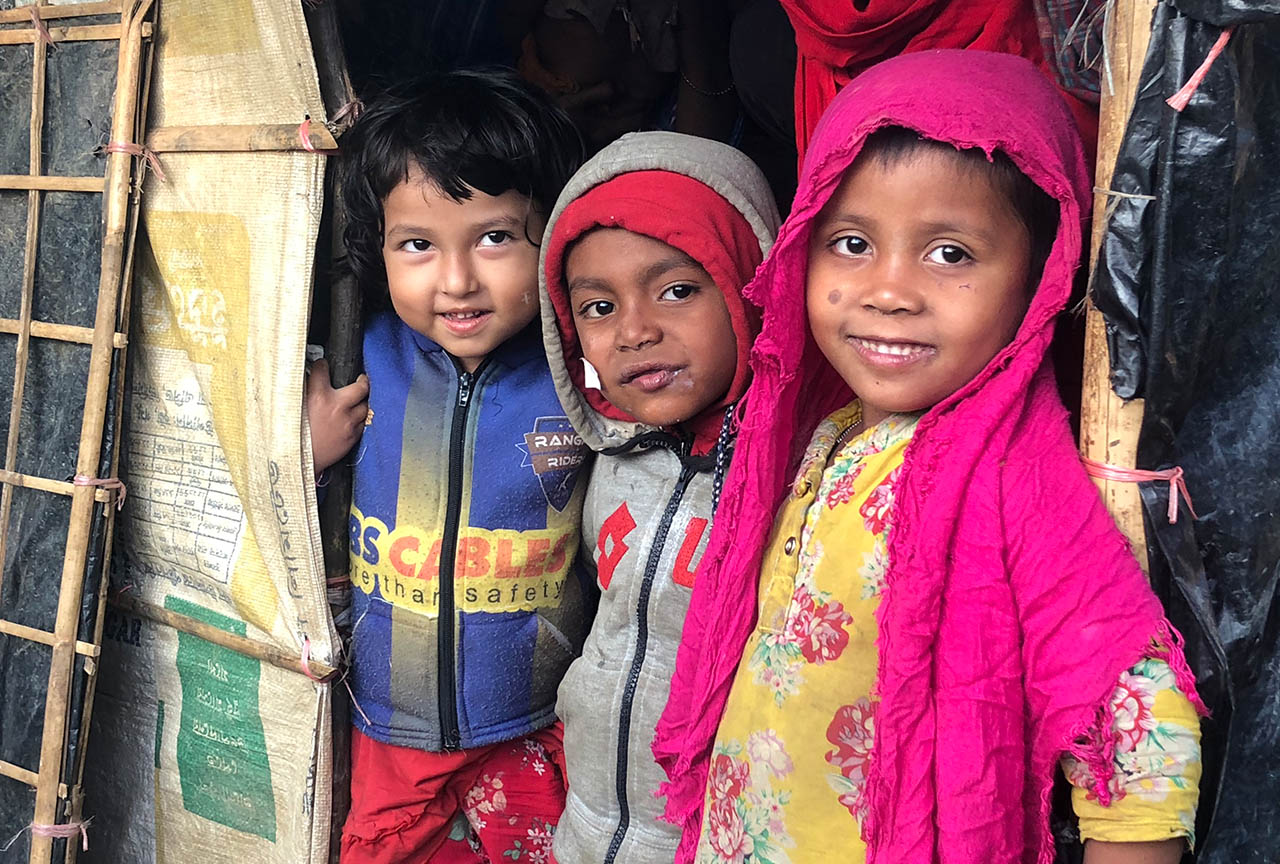 Three Rohingya children in a refugee camp in Bangladesh