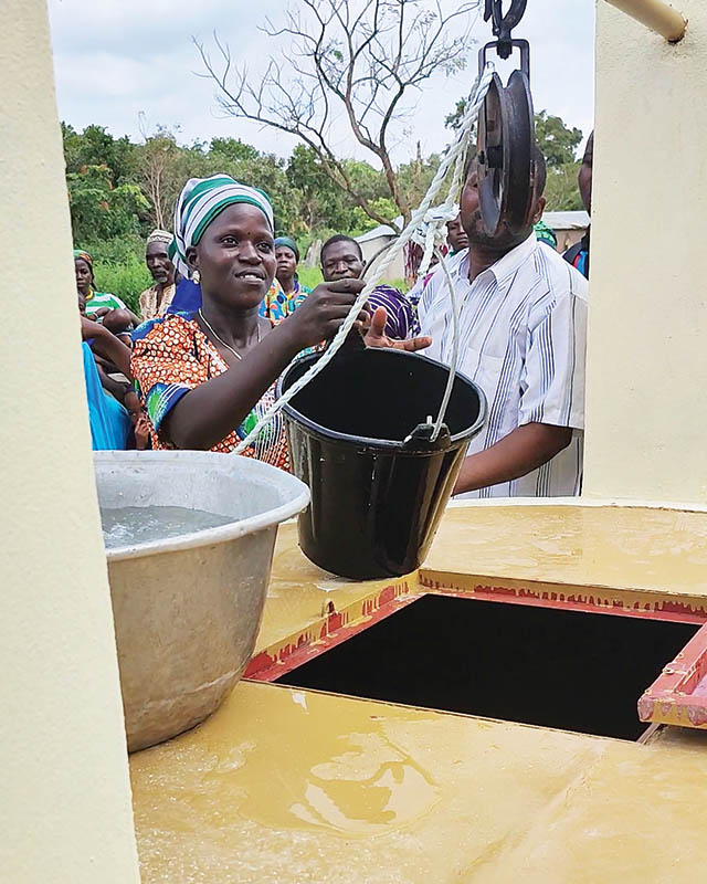 A woman draws water from a newly inaugurated well in a rural community in West Africa.