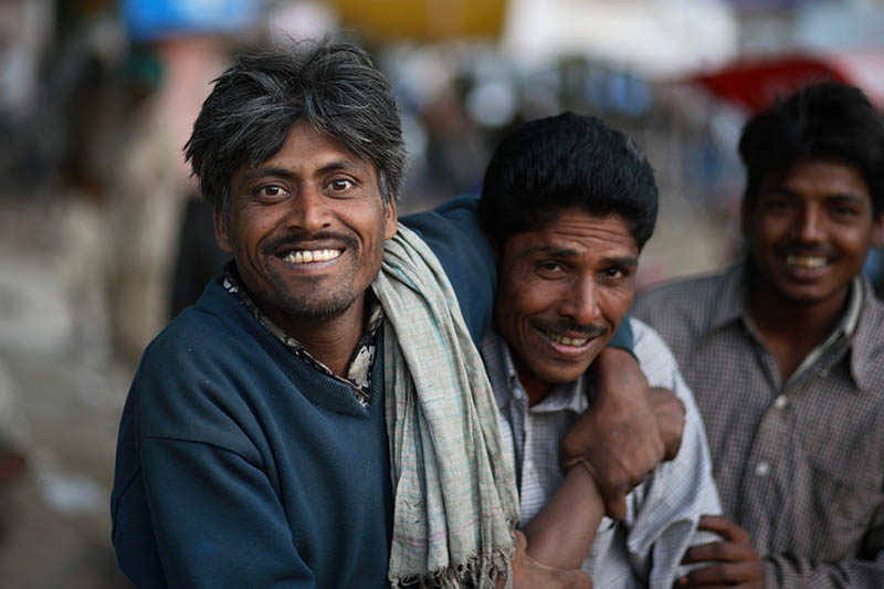 Indian men wrestle and smile at the camera