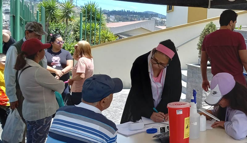Dr Parking gives free basic health checks to the public outside the Carapungo Clinic