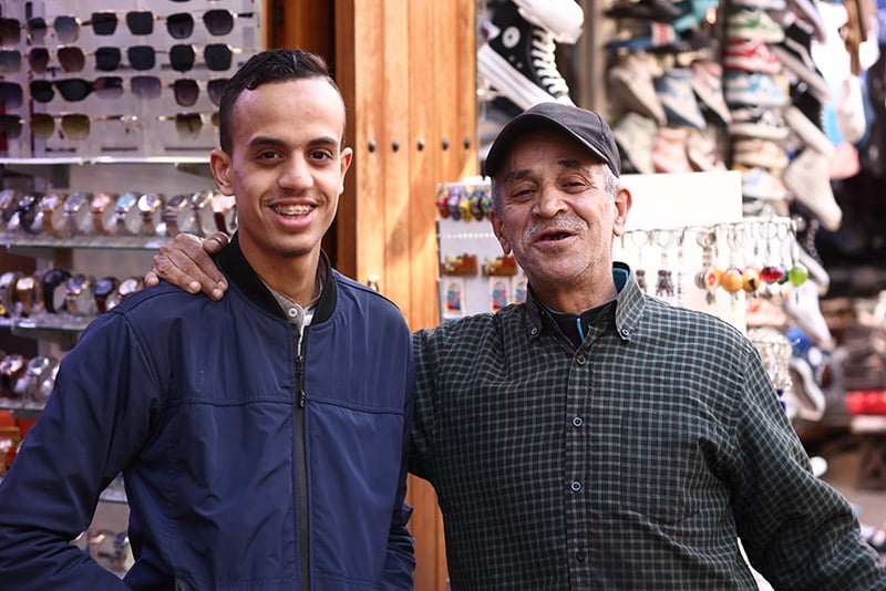 Two generations of Middle-Eastern men smiling