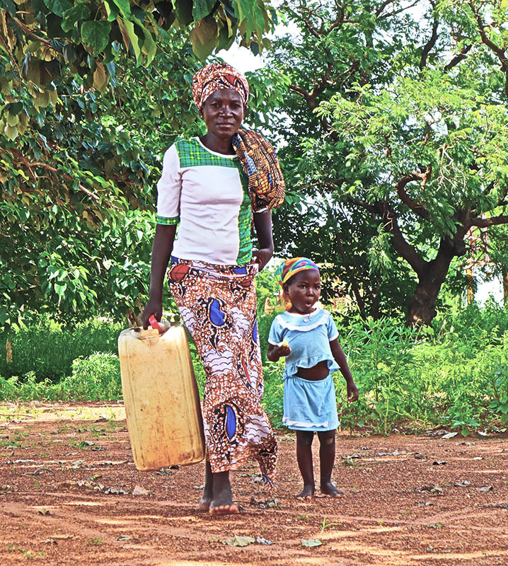 Woman and child carrying a jug of water