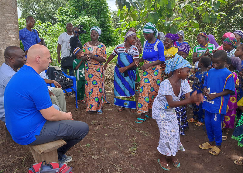 Wim watches villagers dance to celebrate the inauguration of a new well in their community