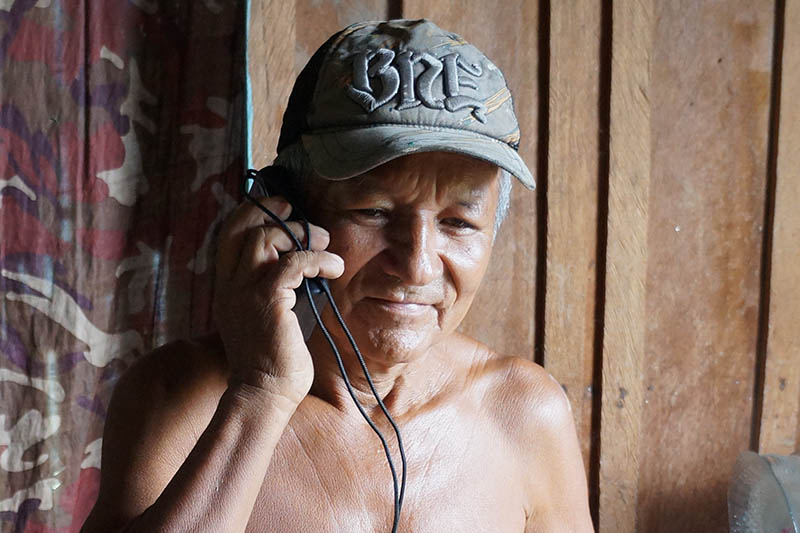 A man living along the Amazon River listens to a Player of Hope