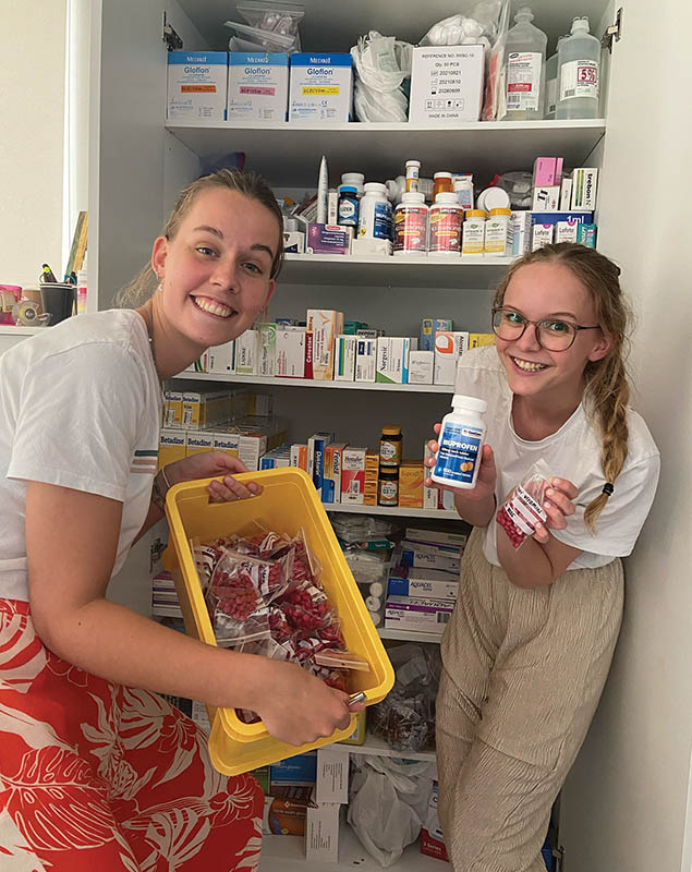 Two nursing students from the Netherlands prepare packages of medicines