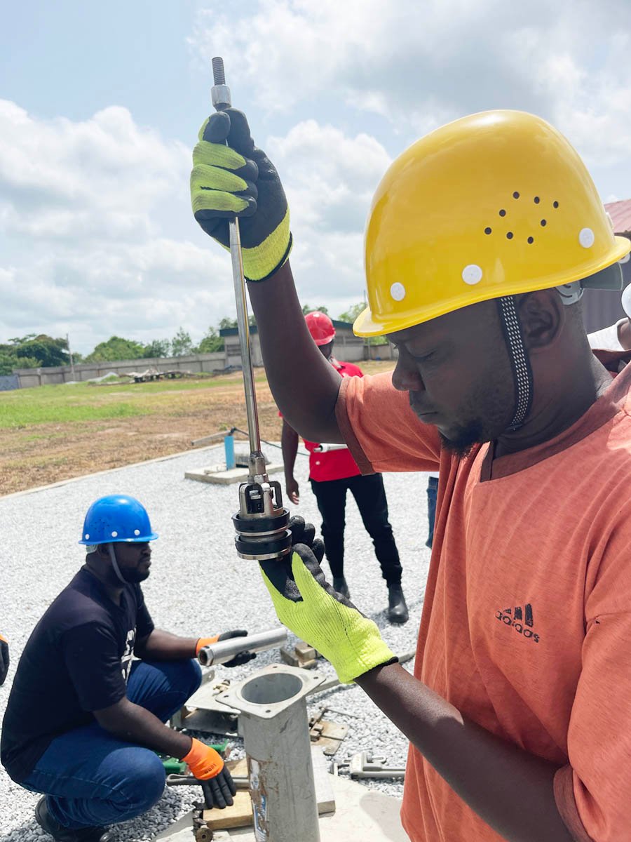 A man inspects the inner seals of a dissambled pump during a Reach Beyond training with partner Friends in Action 