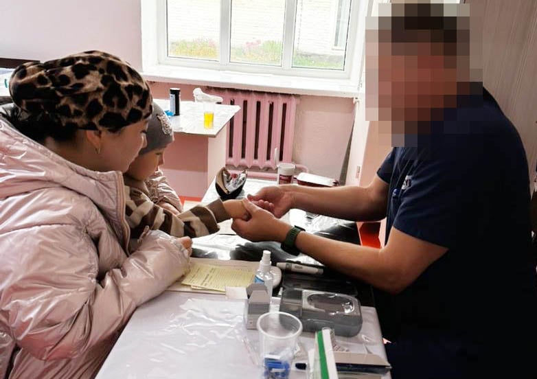 Dr. Luke examines the hands of a child.  