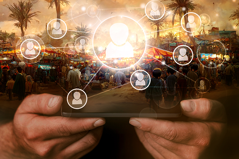 Graphic of social media - hands holding a phone in the foreground,with graphics of social media set over a Middle Eastern market scene at sunset 