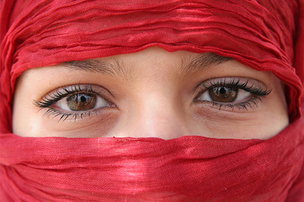 a middle-eastern woman wearing a red head covering