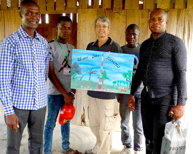 Local believers present Jean Meuhlfelt with a painting of the new tower and surrounding area.