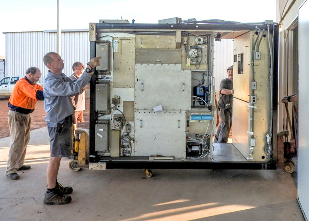 Staff members begin unpacking the refurbished transmitter.