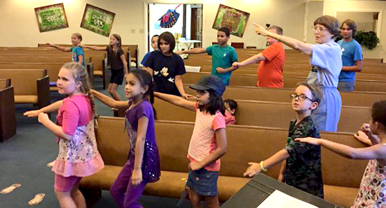 Linda participates in the choreography of a Bible chorus along with some children at First Baptist Church of Harbor Oaks in Florida.