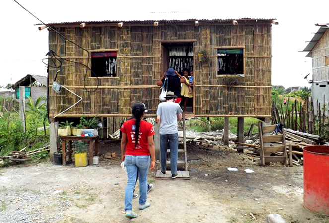 The Quito team visits a newly constructed home of Lucy Barry. People from the Mompiche congregation had built this house before the Quito team arrived to help.