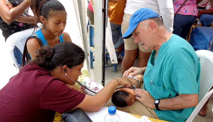Reach Beyond's Dr. Steve Nelson and a local physican, Dr. Paola Perez, check the conditon of a small baby.
