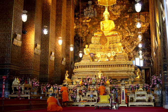Monks worship at a Buddhist shrine in Thailand.