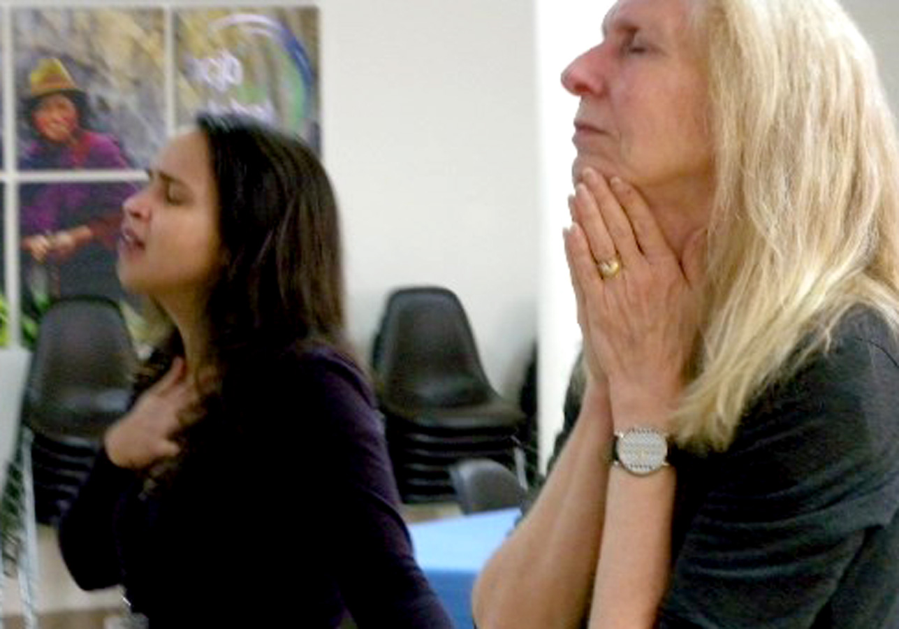 Daneli Ureña (left) and Jane Overstreet pray at the event.